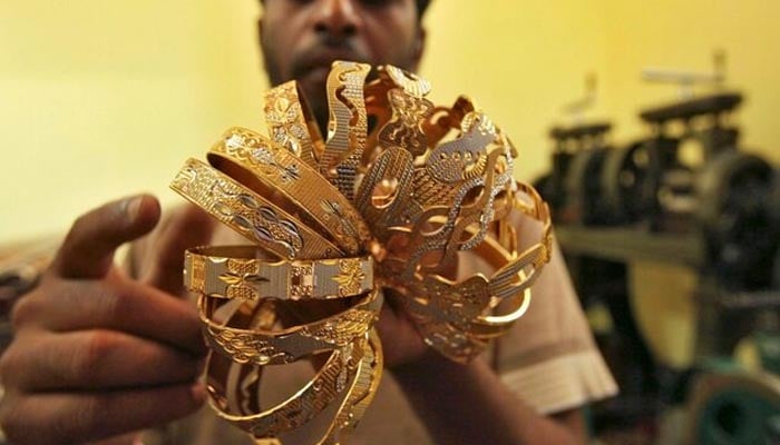 A worker counts gold bangles at a jewellery-making workshop in Jammu October 17, 2011. —Reuters