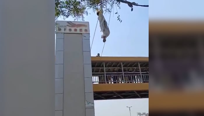 The mobile phone snatcher hanging from electrical wires in an attempt to escape in Nazimabad, Karachi on March 7, 2025. — Reporter