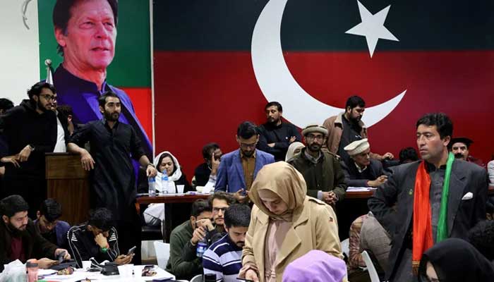 Volunteers for PTI look on as they watch results on TV screens after the end of the polling during the general election at the partys office in Islamabad, , February 8, 2024. — Reuters