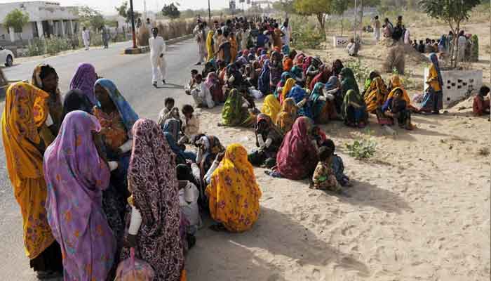 Villagers wait to receive relief supplies outside a military camp in Mithi, the capital of Tharparkar district, some 300 kilometres from Karachi on March 11, 2014. — AFP