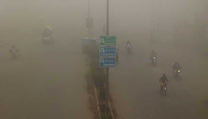 People commute on a smoggy morning in Peshawar, November 11, 2024. — Reuters